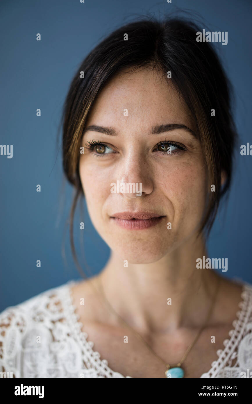 Porträt einer schönen Frau vor blauem Hintergrund Stockfoto
