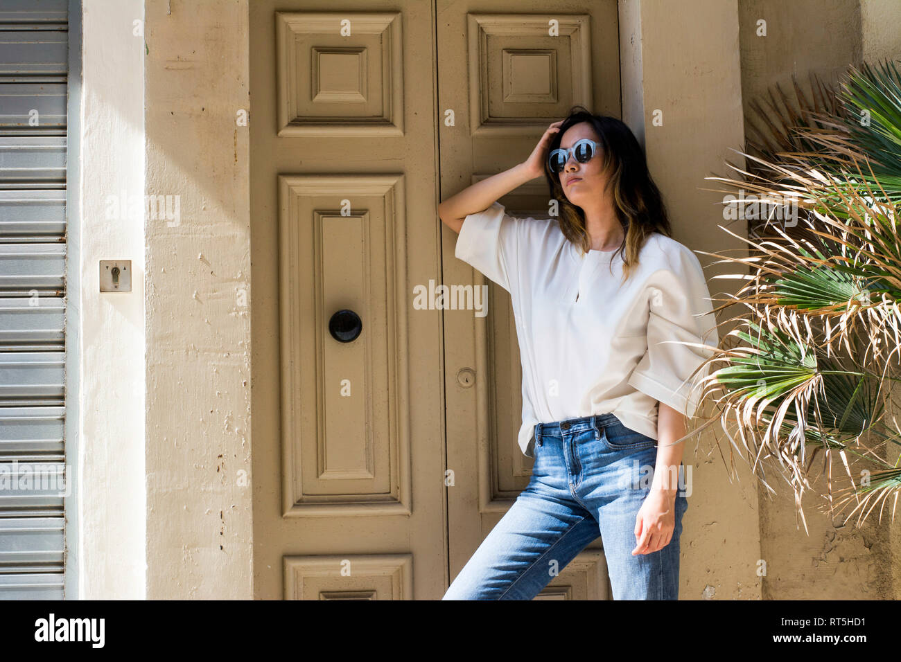 Porträt der jungen Frau mit Sonnenbrille im Haus Eingang schiefen Stockfoto