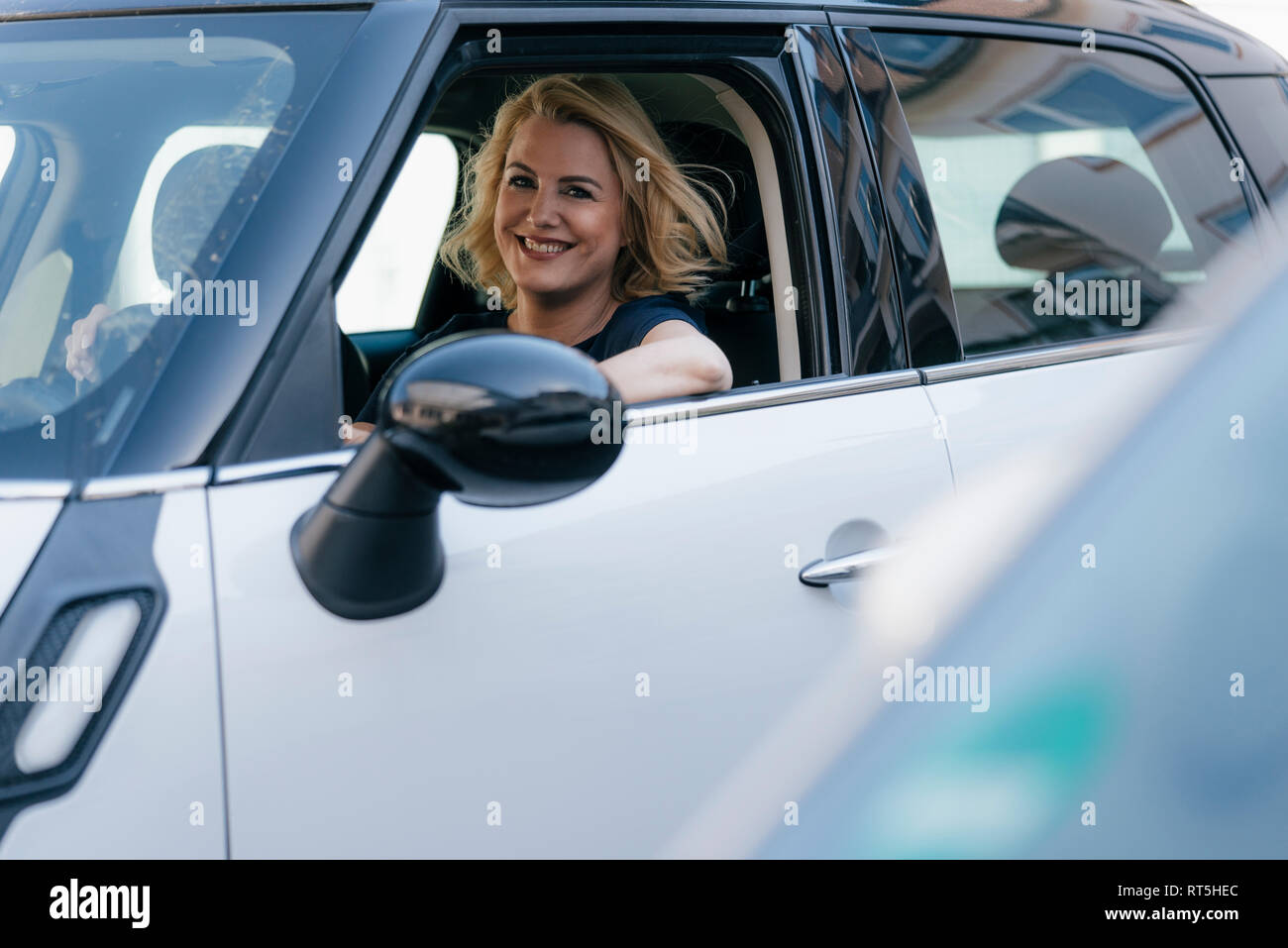 Porträt der lächelnde Frau aus dem Auto Fenster Stockfoto