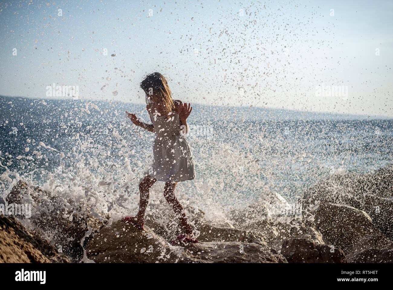 Kroatien, Kvarner, Mädchen zu Fuß durch Spritzwasser Sea Foam auf Felsen Stockfoto
