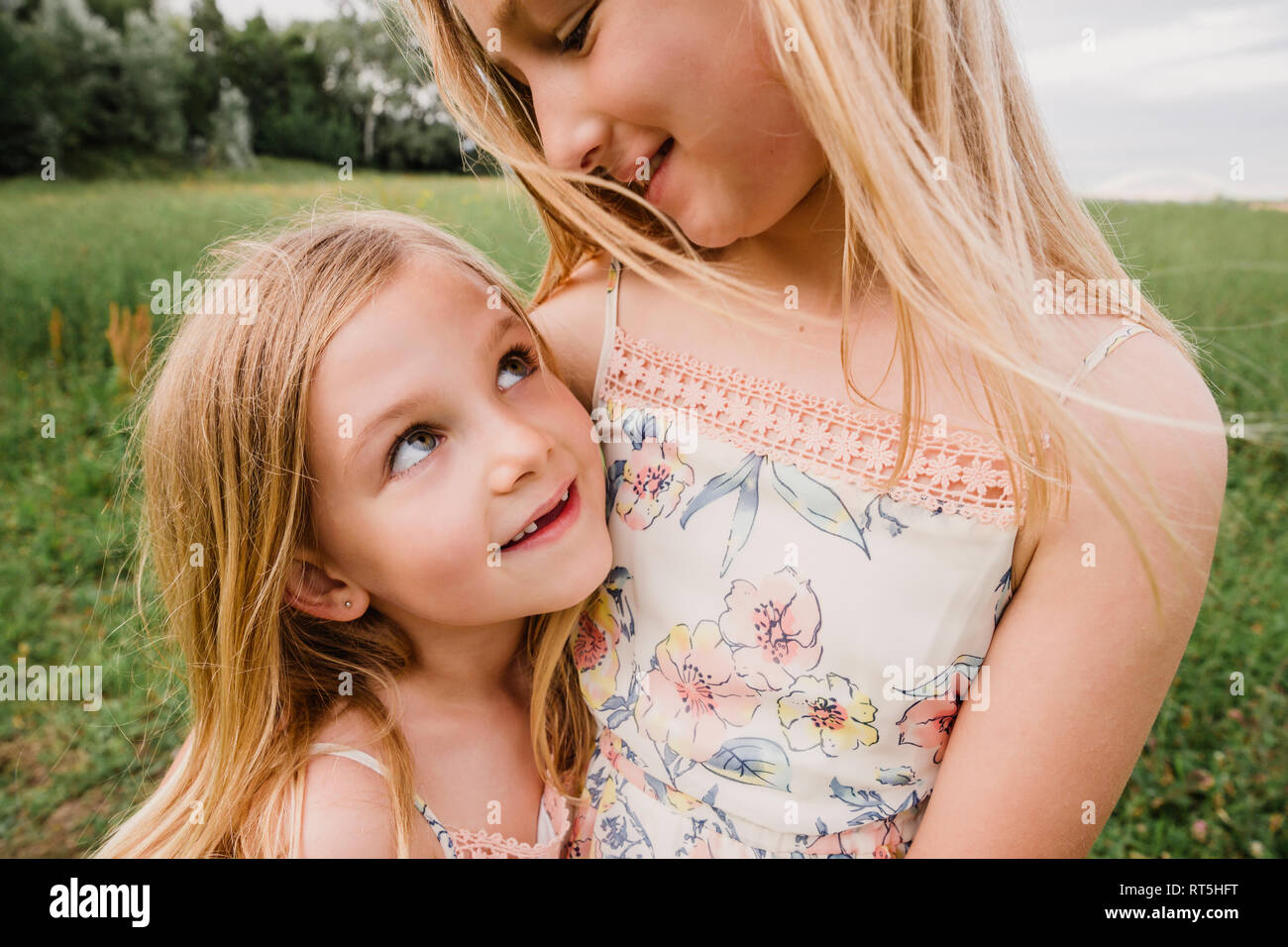 Zwei kleine Schwestern Schmusen auf einer Wiese Stockfoto