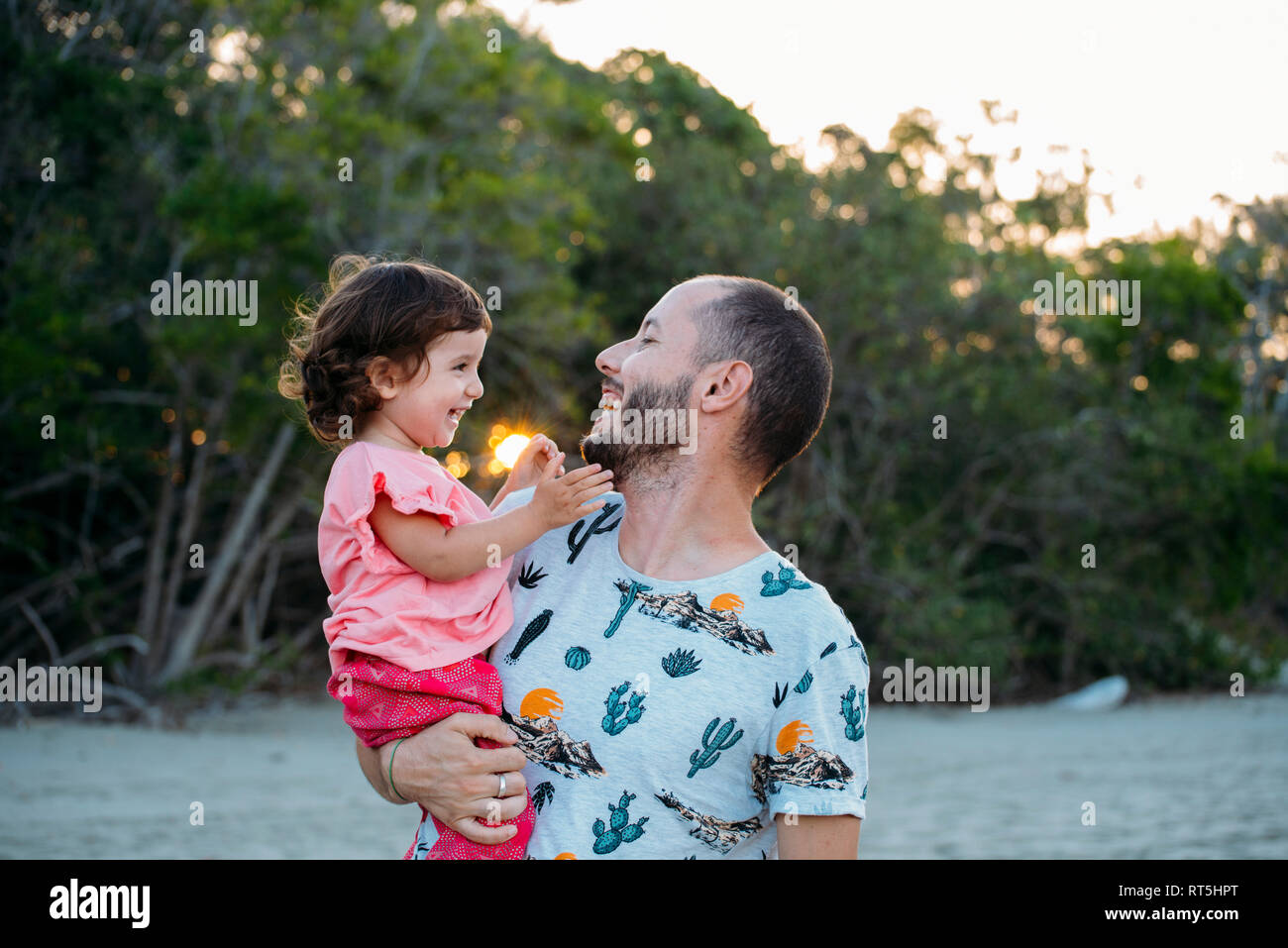 Australien, Queensland, Mackay, Cape Hillsborough National Park, happy Vater seine Tochter an den Strand bei Sonnenuntergang Stockfoto