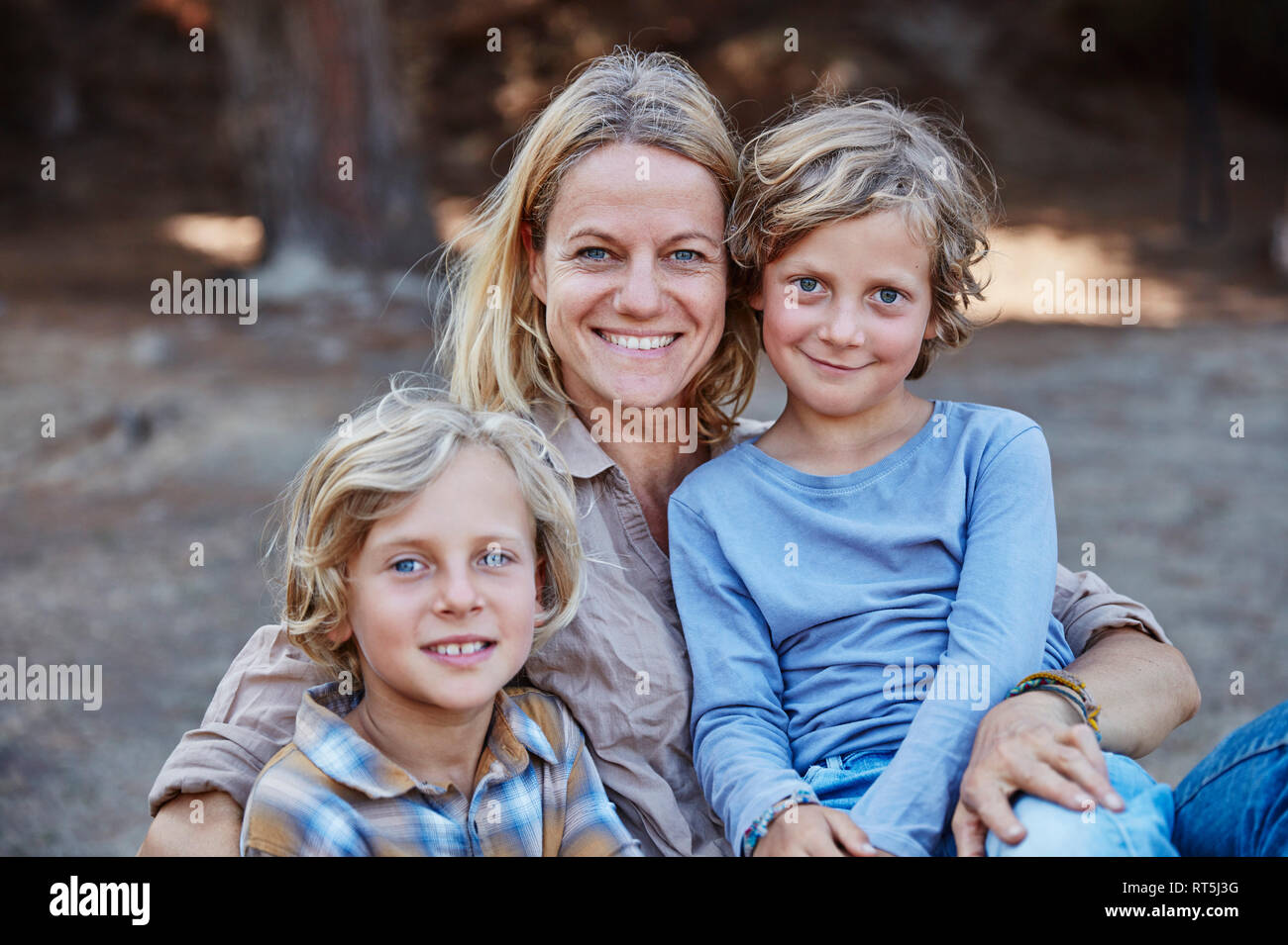 Portrait der glücklichen Mutter mit zwei Söhnen im Freien Stockfoto