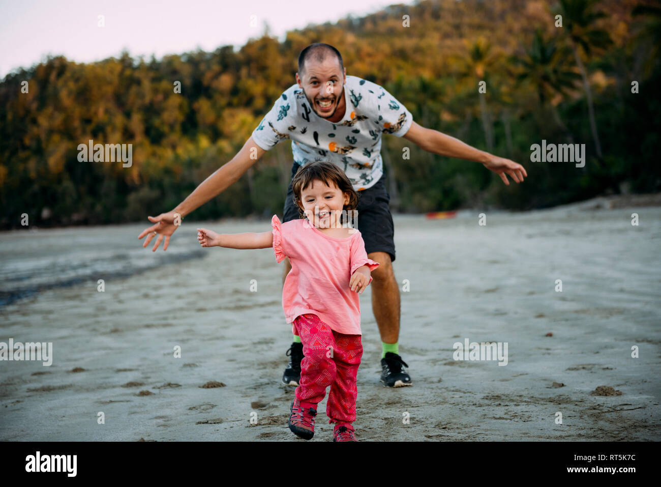 Australien, Queensland, Mackay, Cape Hillsborough National Park, happy Vater laufen, nachdem seine Tochter am Strand Stockfoto