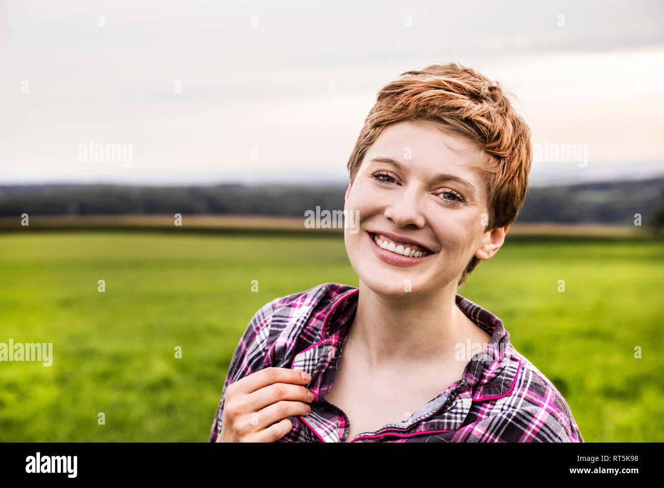 Portrait von lächelnden Frau in Pyjama in ländlichen Landschaft Stockfoto