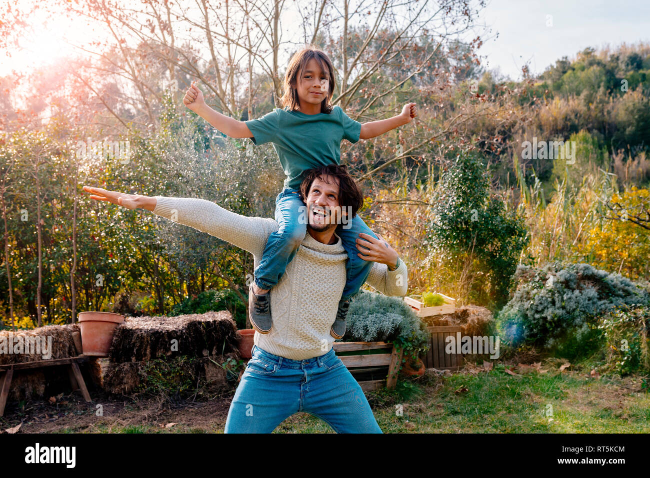 Vater mit Sohn Huckepack in einem Garten in der Landschaft Stockfoto