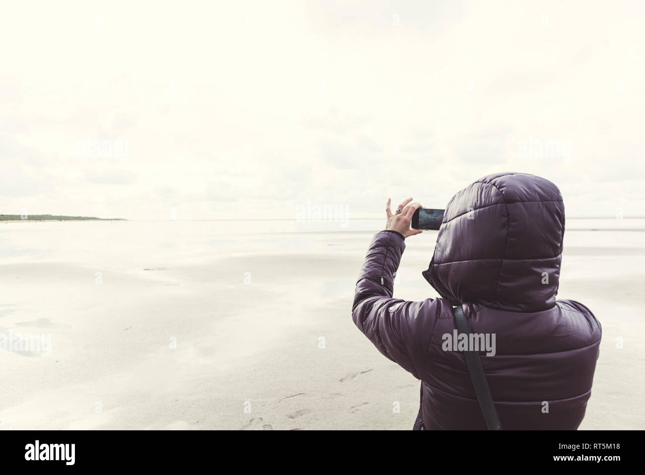 Niederlande, Ouddorp, Rückansicht der Frau unter selfie am Strand im Herbst Stockfoto