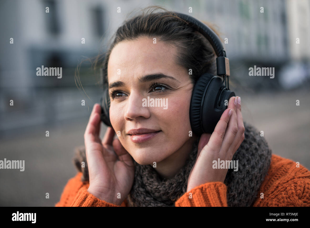 Porträt der lächelnde Frau tragen Musik hören mit kabellose Kopfhörer im Herbst Stockfoto