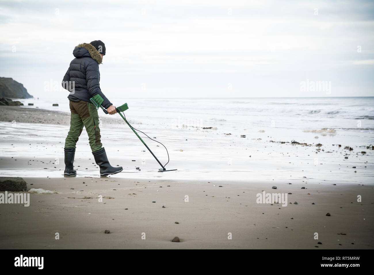 Mann mit Metalldetektor am Sandstrand Stockfoto