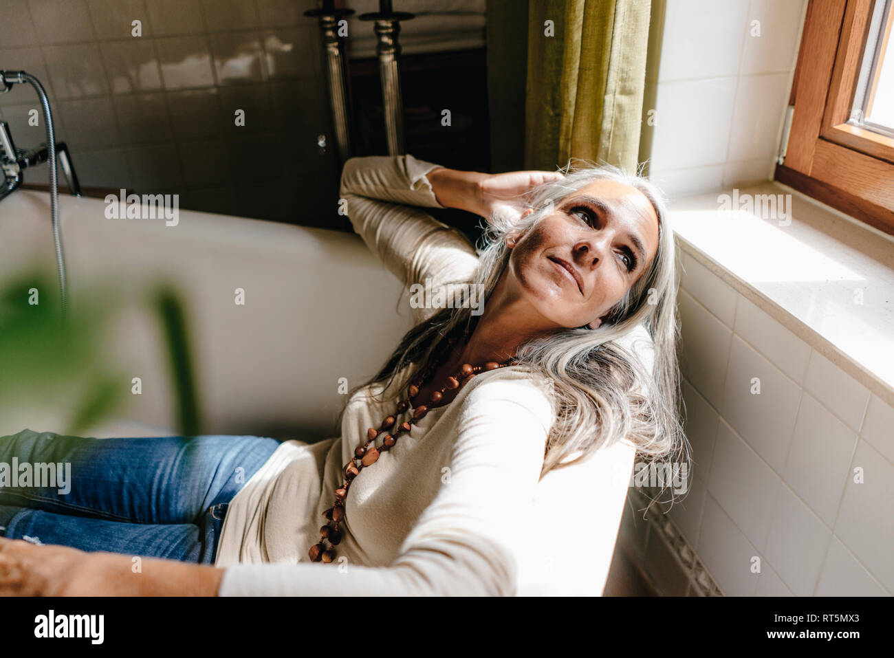 Portrait von gekleidete Frau in der Badewanne sitzen Stockfoto