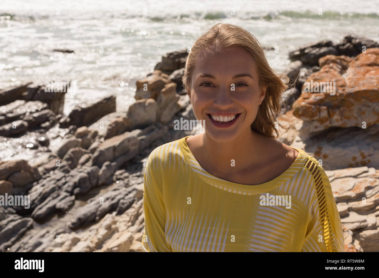 Frau entspannend auf den Felsen am Strand Stockfoto