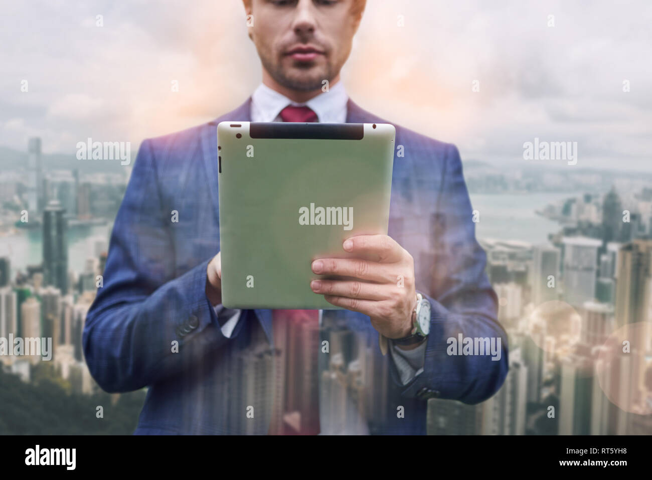 IT-Experte überzeugt. Close-up Portrait von Geschäftsmann in Anzug mit digitalen Tablet beim Stehen vor der Stadtbild Hintergrund. Digital. Internet. Kommunikation Stockfoto