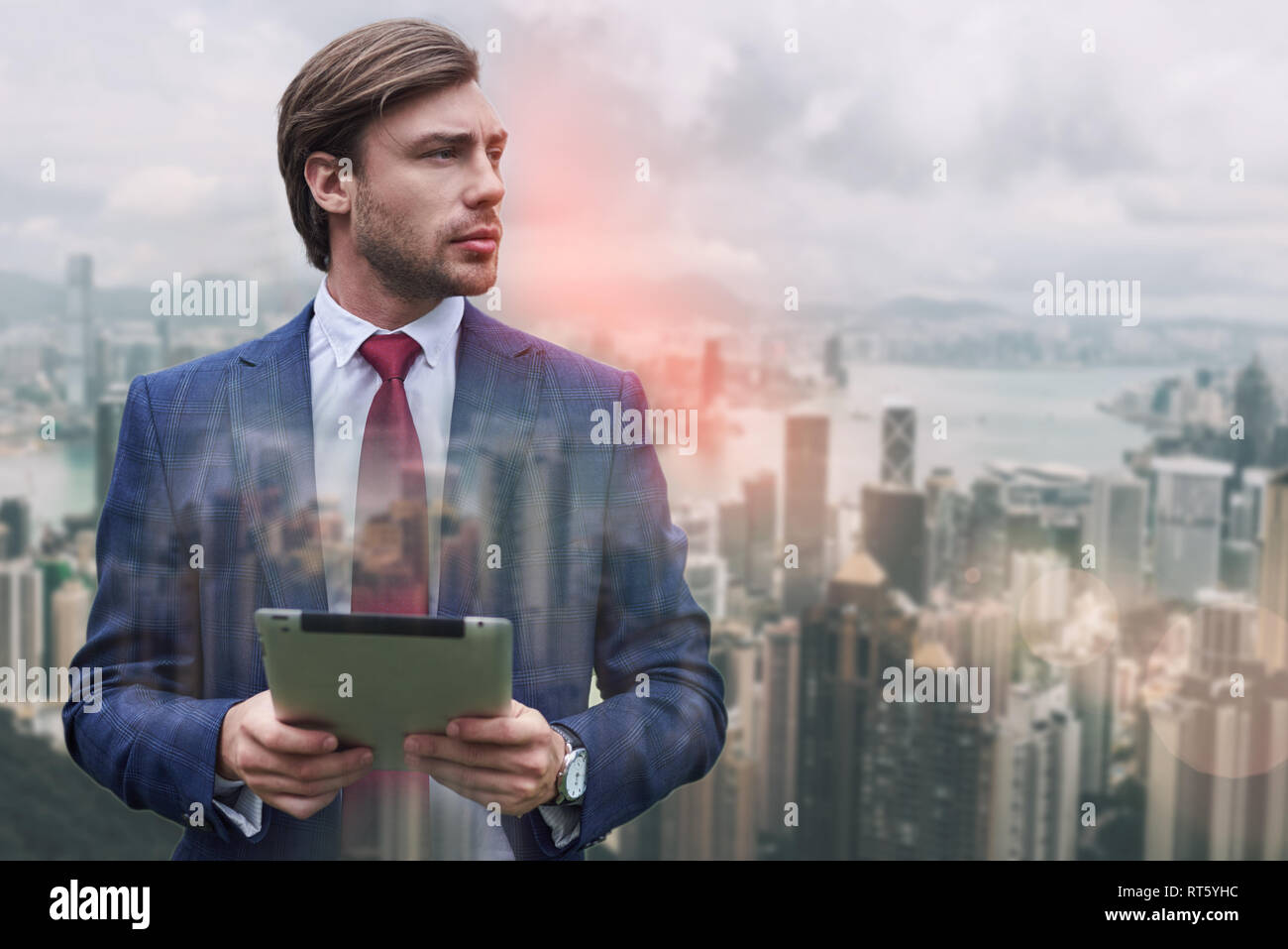 Bereit zu arbeiten. Stilvolle bärtigen Geschäftsmann seine digitale Tablet halten und gegen von stadtbild Hintergrund stehen. Digital. Internet. Kommunikation Stockfoto