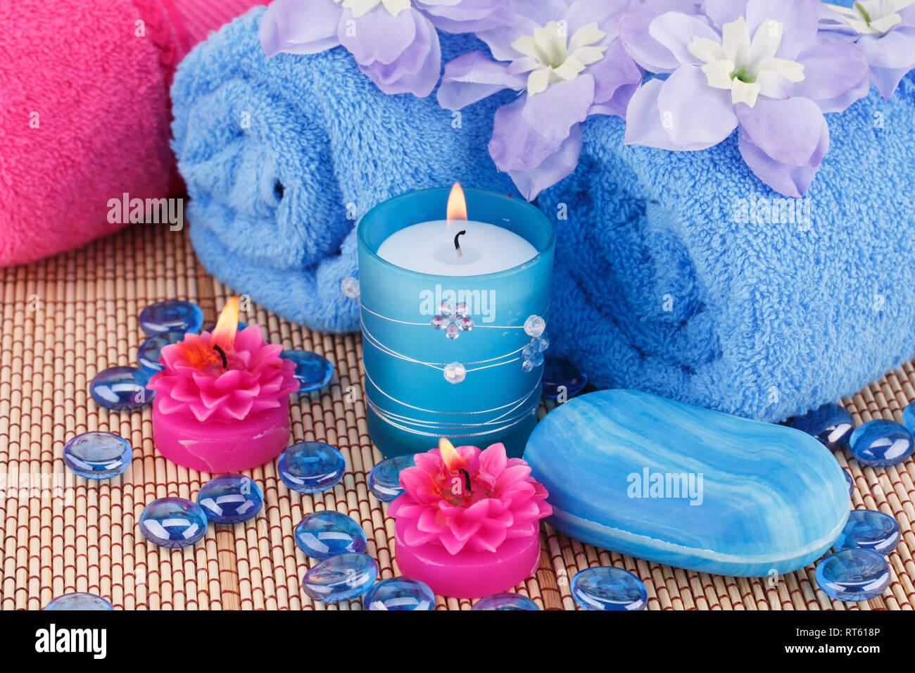Spa mit Handtüchern, Seifen, Kerzen und Blumen auf Bambus Hintergrund. Stockfoto