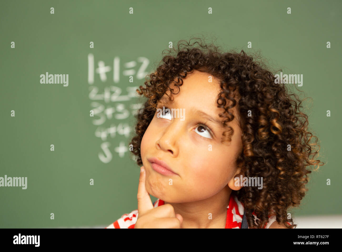 Die Schülerin gegen grüne Board in einem Klassenzimmer in der Schule Stockfoto