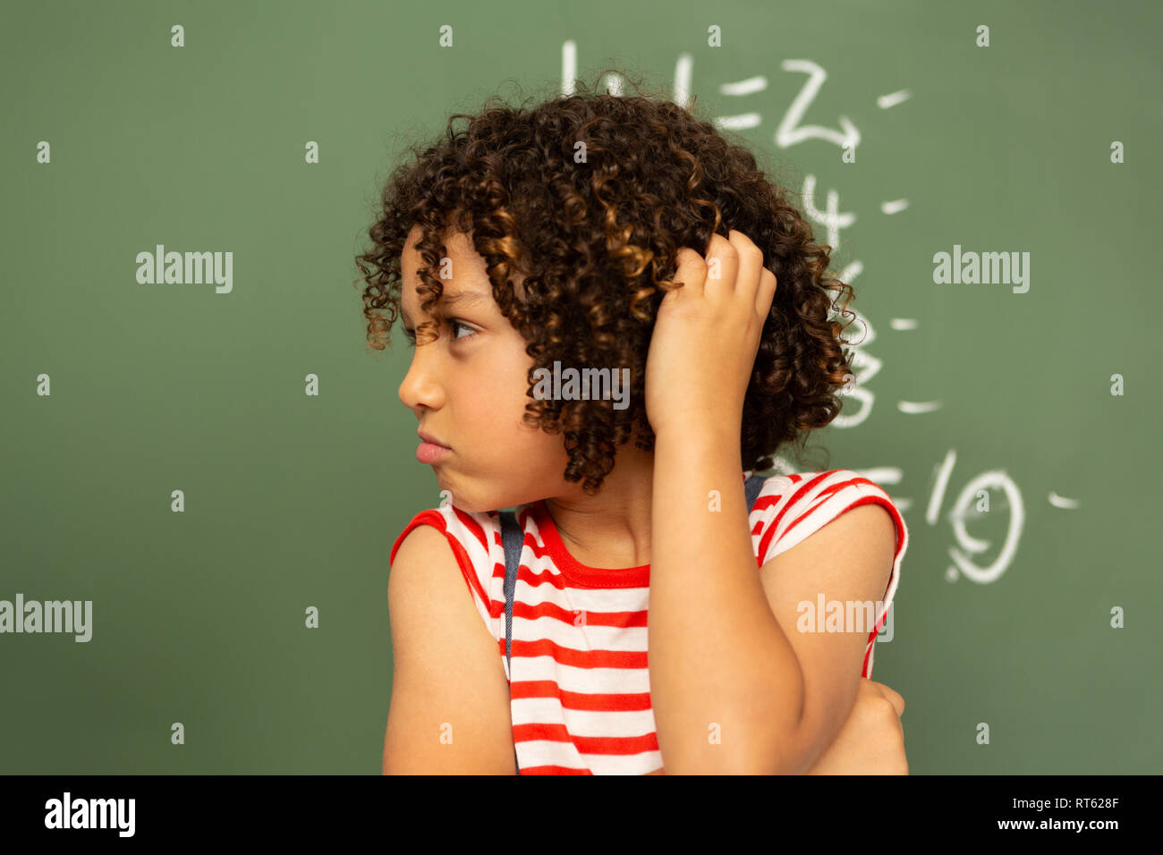 Die Schülerin gegen grüne Board in einem Klassenzimmer in der Schule Stockfoto