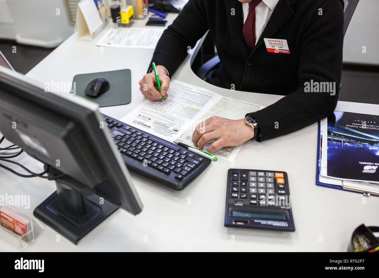GRODNO, Weißrussland - AUGUST 2017: Mitarbeiter, um den Anruf zu beantworten im Store an der Arbeit am Computer im modernen Shop Stockfoto