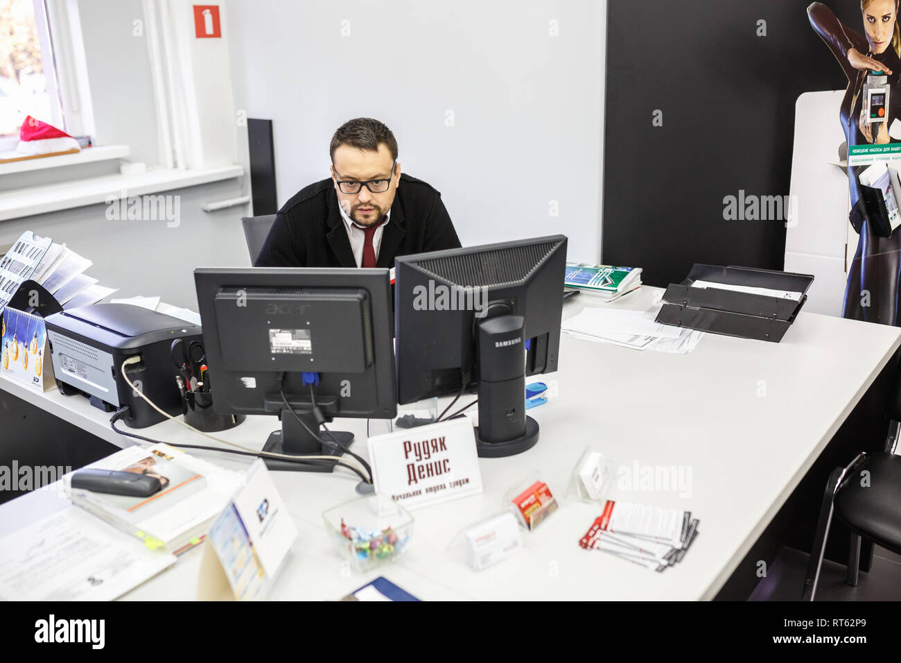 GRODNO, Weißrussland - AUGUST 2017: Mitarbeiter, um den Anruf zu beantworten im Store an der Arbeit am Computer im modernen Shop Stockfoto