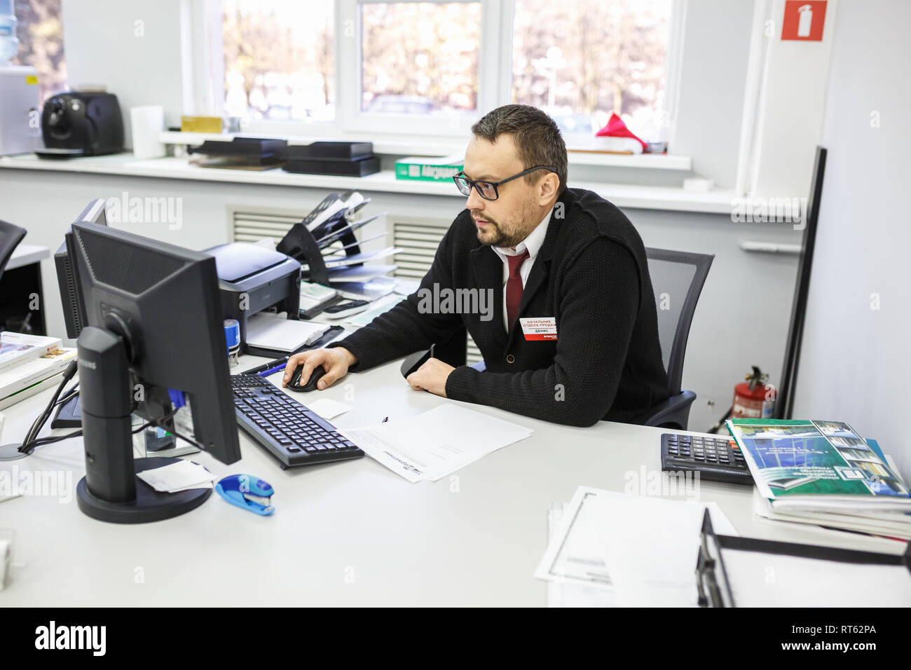 GRODNO, Weißrussland - AUGUST 2017: Mitarbeiter, um den Anruf zu beantworten im Store an der Arbeit am Computer im modernen Shop Stockfoto