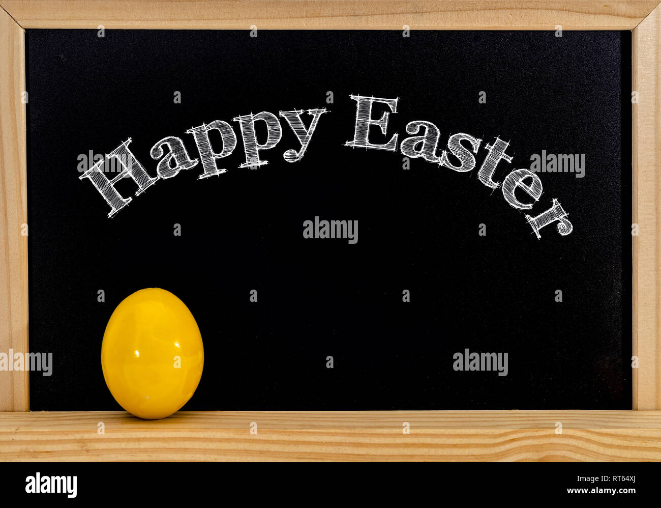 Ostern Rahmen mit bemalten Eiern und Schiefertafel. Frohe Ostern in weißer Kreide. Stockfoto