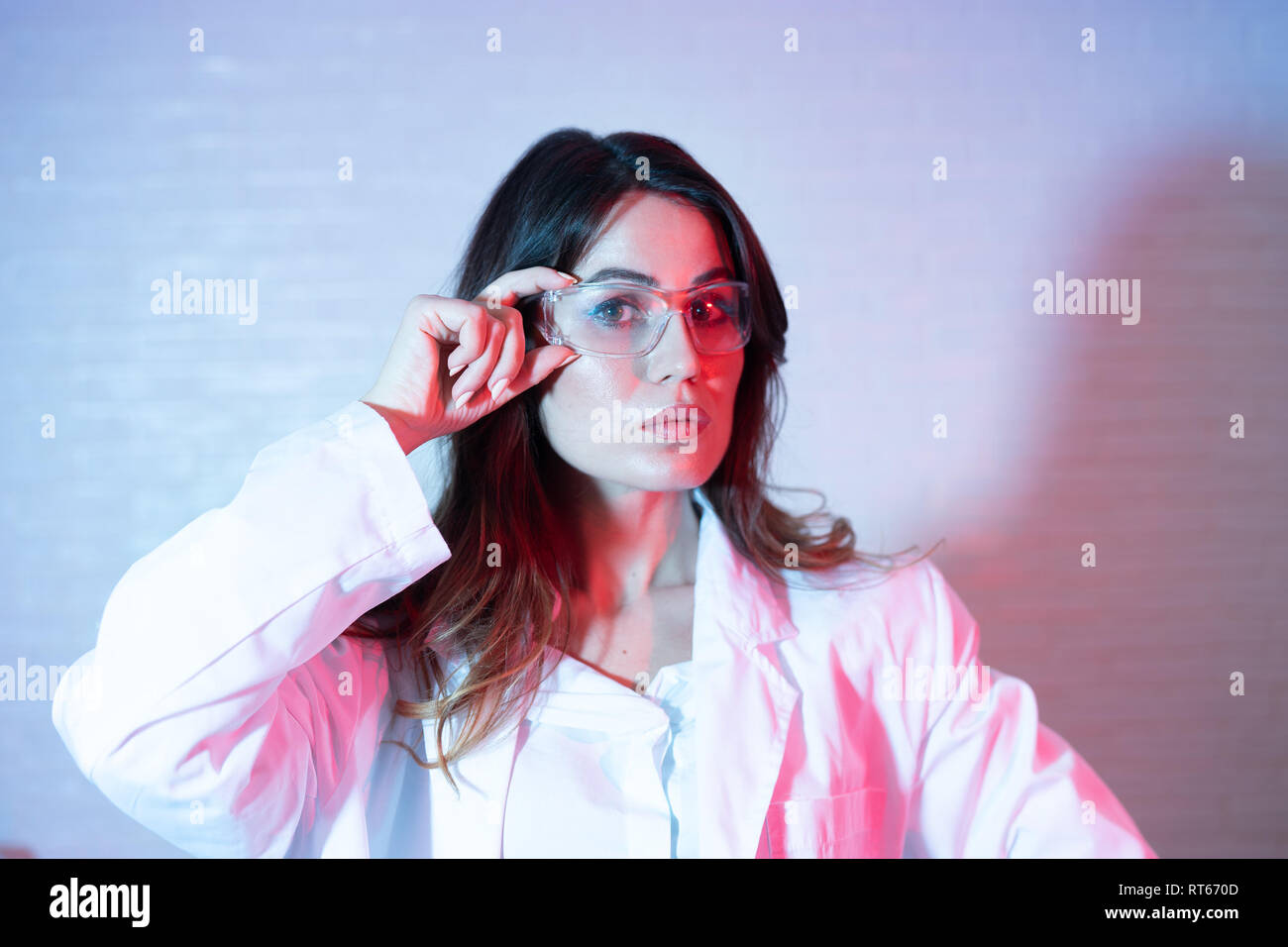 Porträt der schönen Wissenschaftlerin in Gläsern mit trendigen Duplex blau und rosa Wirkung Stockfoto