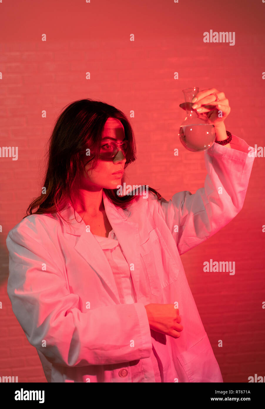 Porträt der schönen Wissenschaftlerin in Gläsern mit trendigen rot Neon Lichteffekt Stockfoto