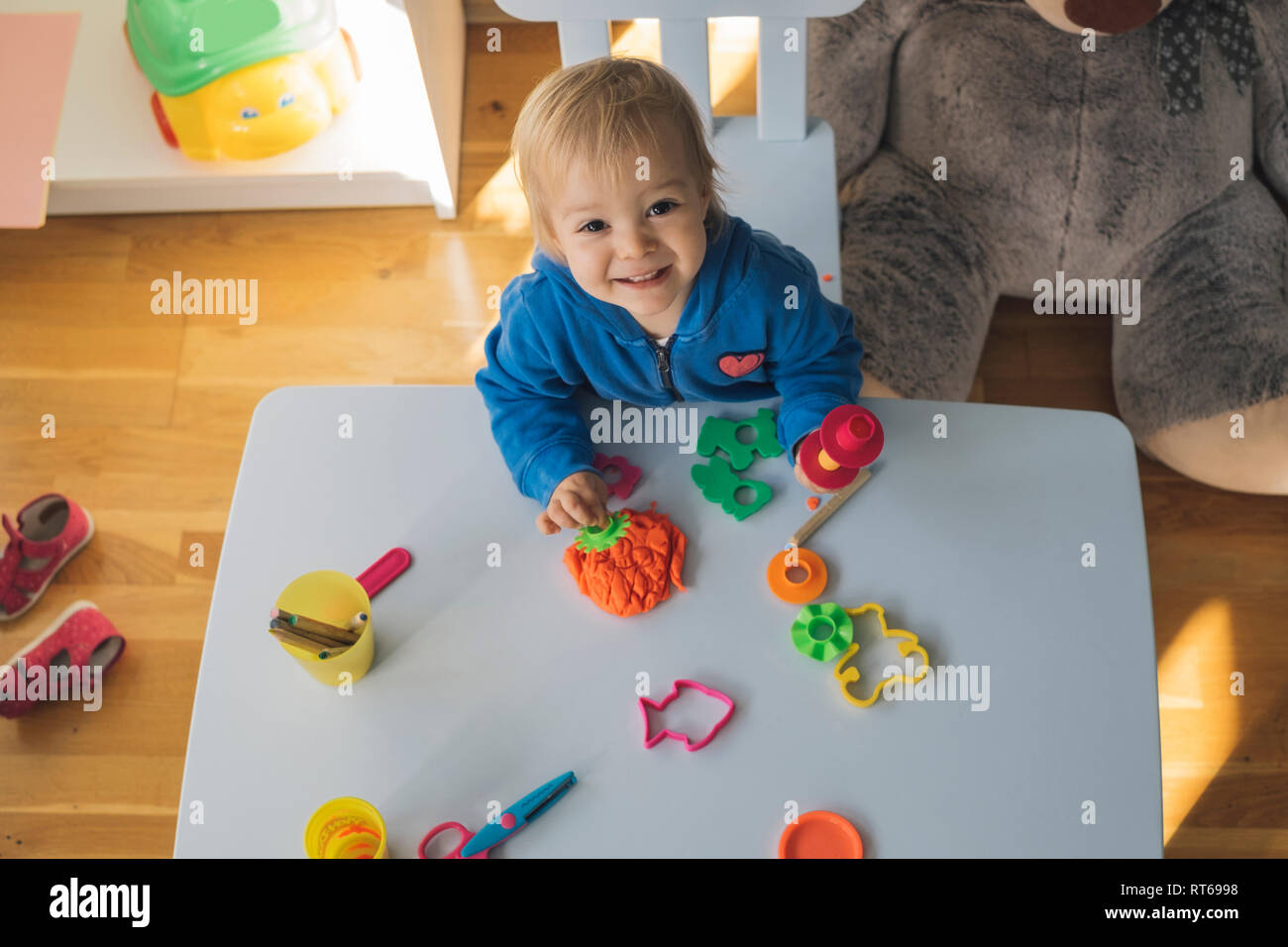 Portrait von lächelnden Mädchen spielen mit Knetmasse im Kinderzimmer Stockfoto