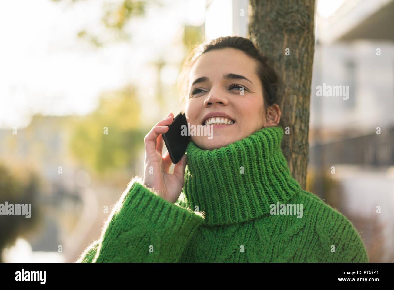 Portrait von glücklichen Frau am Telefon das Tragen von grünen rollkragen pullover im Herbst Stockfoto