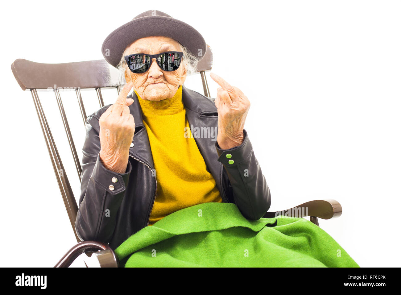 Alte Frau mit Hut und Sonnenbrille auf dem Stuhl verkleidet mit grüner Decke. Stockfoto