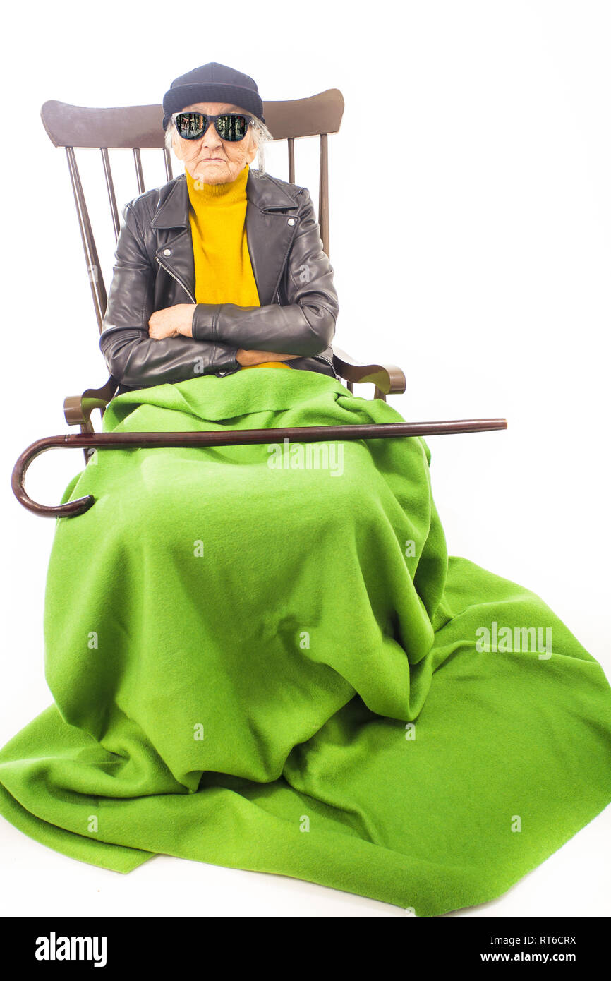 Alte Frau mit Hut und Sonnenbrille auf dem Stuhl Stockfoto