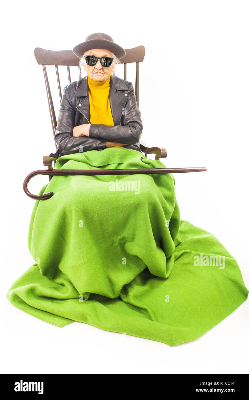 Alte Frau mit Hut und Sonnenbrille auf dem Stuhl Stockfoto