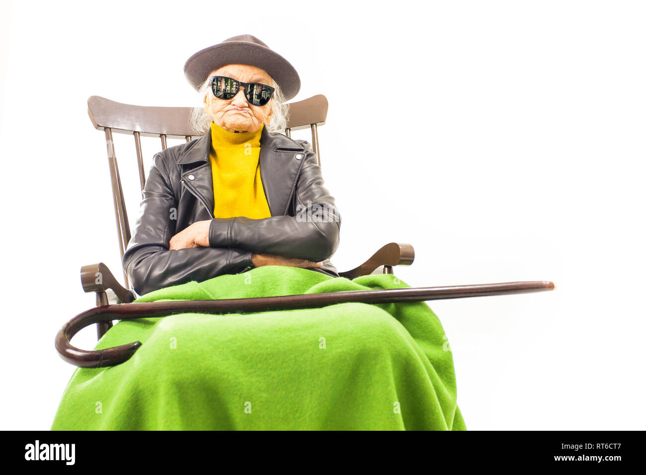 Alte Frau mit Hut und Sonnenbrille auf dem Stuhl Stockfoto