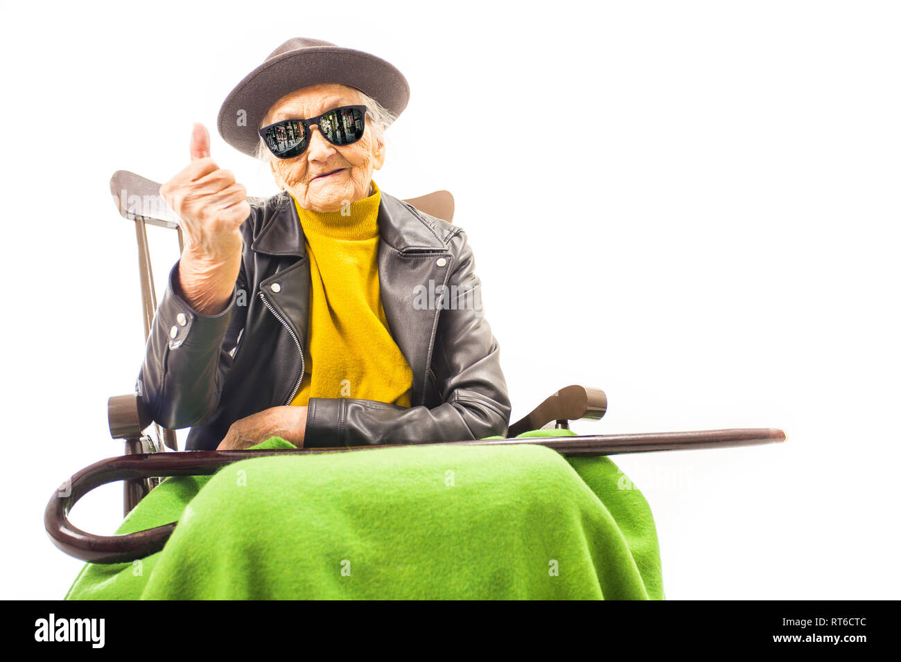 Alte Frau mit Hut und Sonnenbrille auf dem Stuhl Stockfoto
