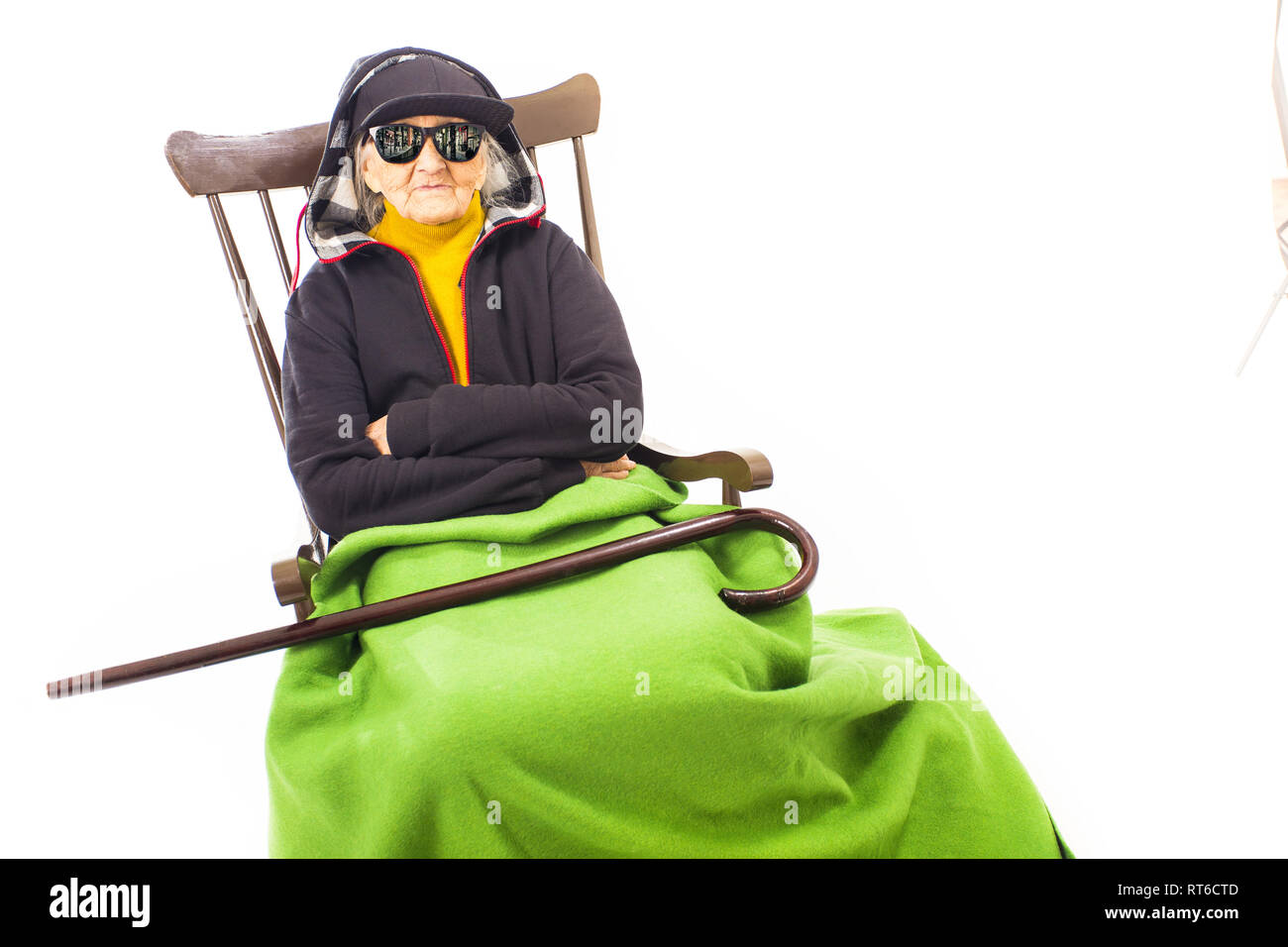 Alte Frau mit Hut und Sonnenbrille auf dem Stuhl Stockfoto