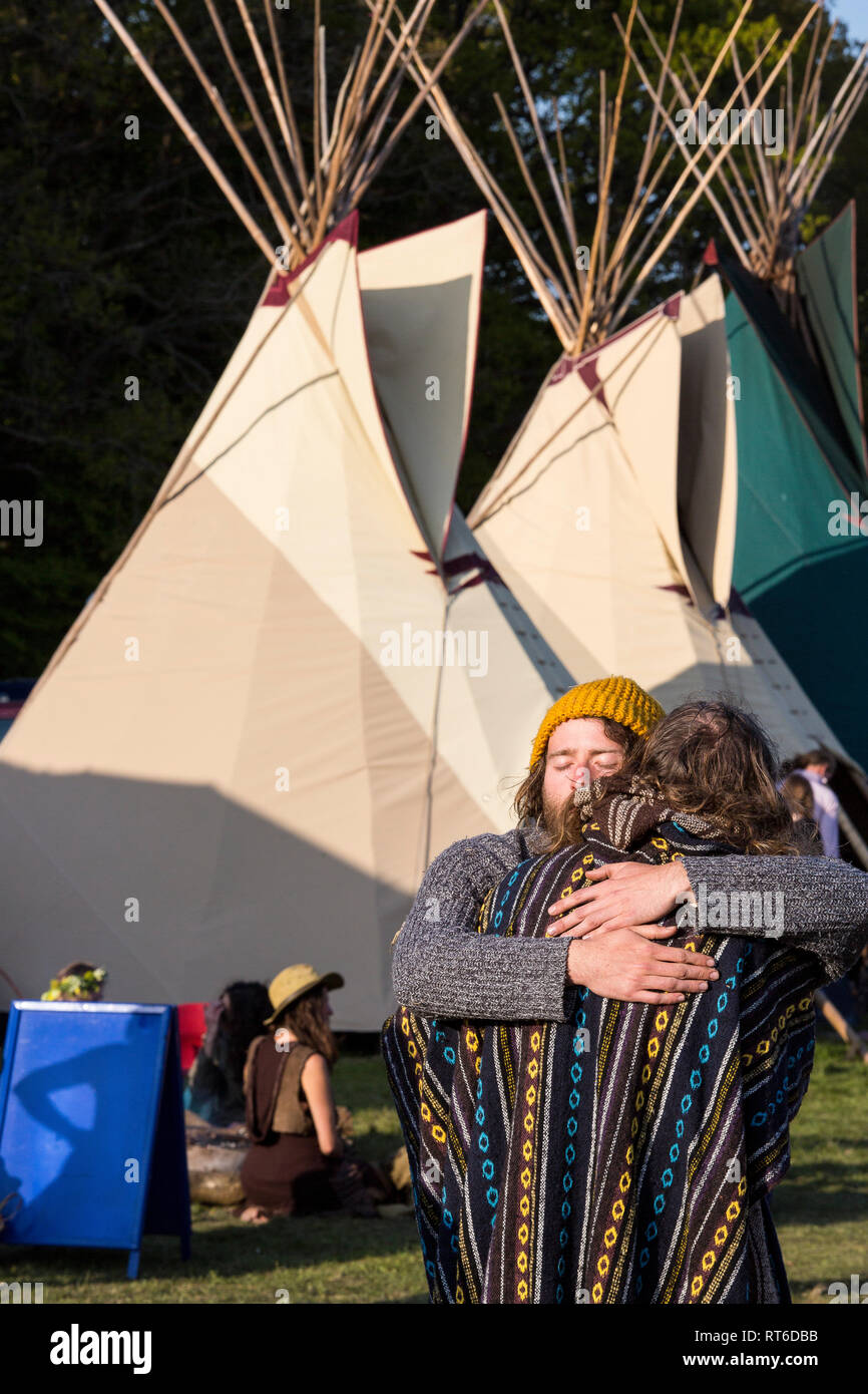 Zwei Menschen, die eine große Umarmung an Beltane Fire Festival, Sussex, UK Stockfoto