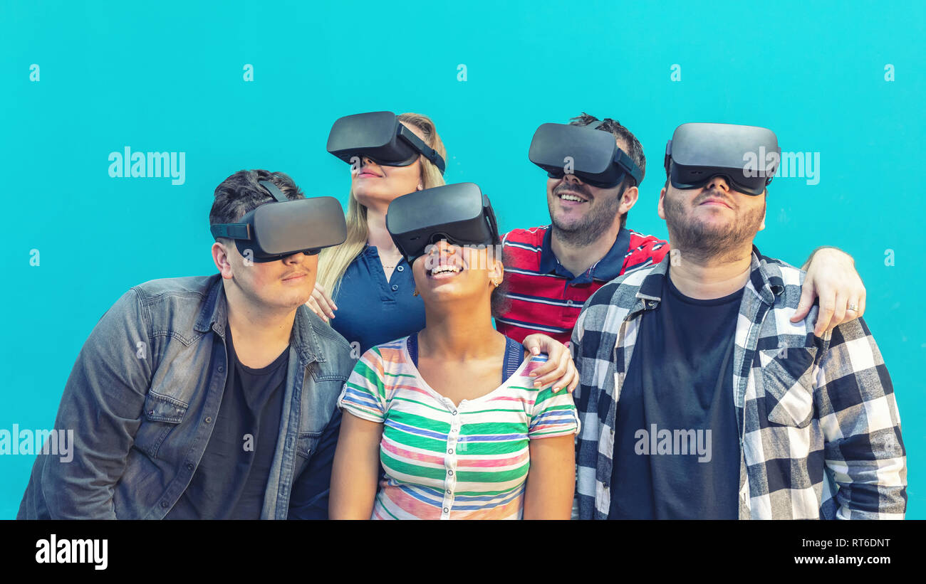 Multiethnische Gruppe von Freunden, die Virtual Reality Spiele auf VR-Brille indoor Stockfoto