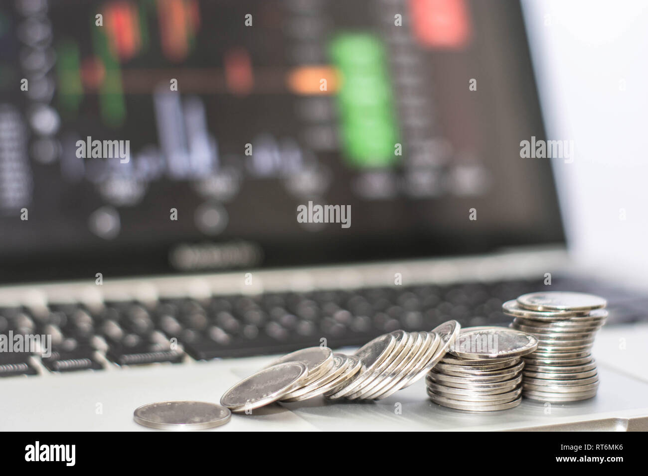 Silber münze mit Monitor zeigt Handel Verkehr, Bitcoin minning, Münze colapse vor Monitor Laptop. Online Transaktion Konzept Stockfoto
