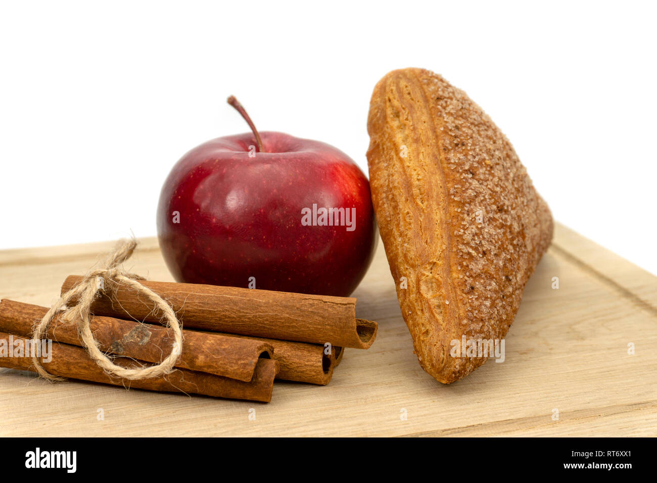 Hausgemachte Blätterteig apple Umsätze, Apple und Zimtstangen auf einer hölzernen Schneidebrett isoliert auf weißem Hintergrund Stockfoto