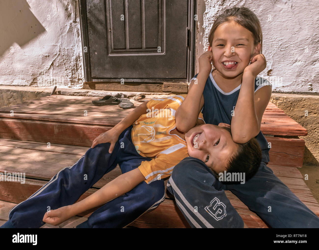 Kasachischen Bruder und Schwester es Hamming für die Kamera, Altyn Emel Naitonal Park, Kasachstan Stockfoto