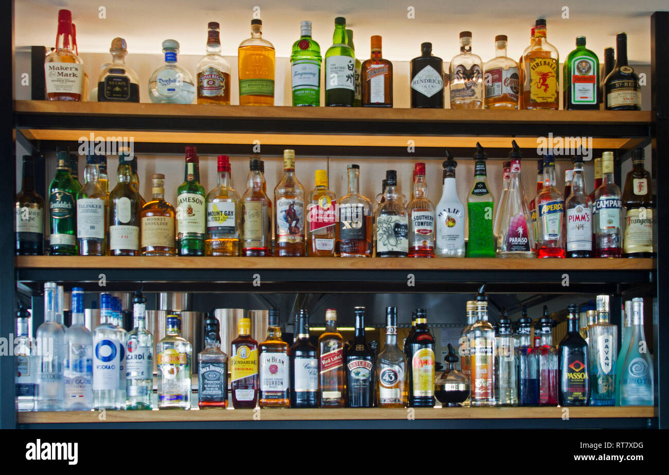 Regale vollgestopft mit bunten Flaschen alkoholischer Getränke in einer Bar/Pub Stockfoto