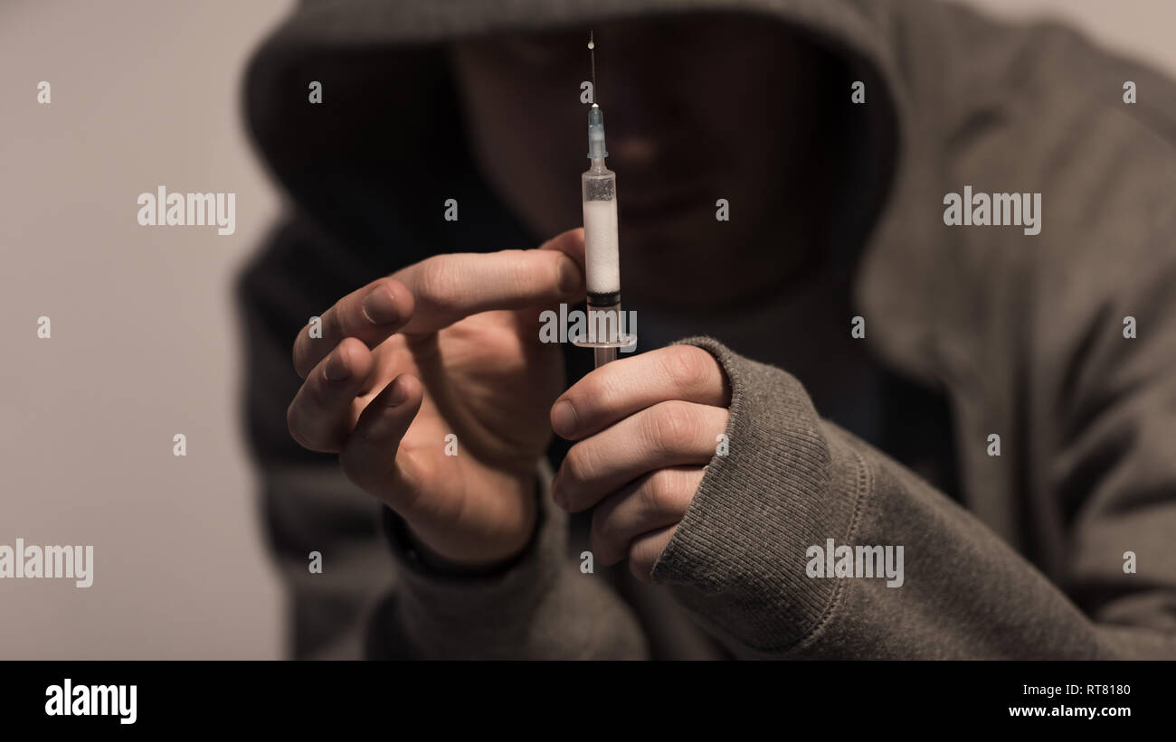 Selektiver Fokus der Junkie Mann, Spritze mit der Dosis von Heroin Stockfoto