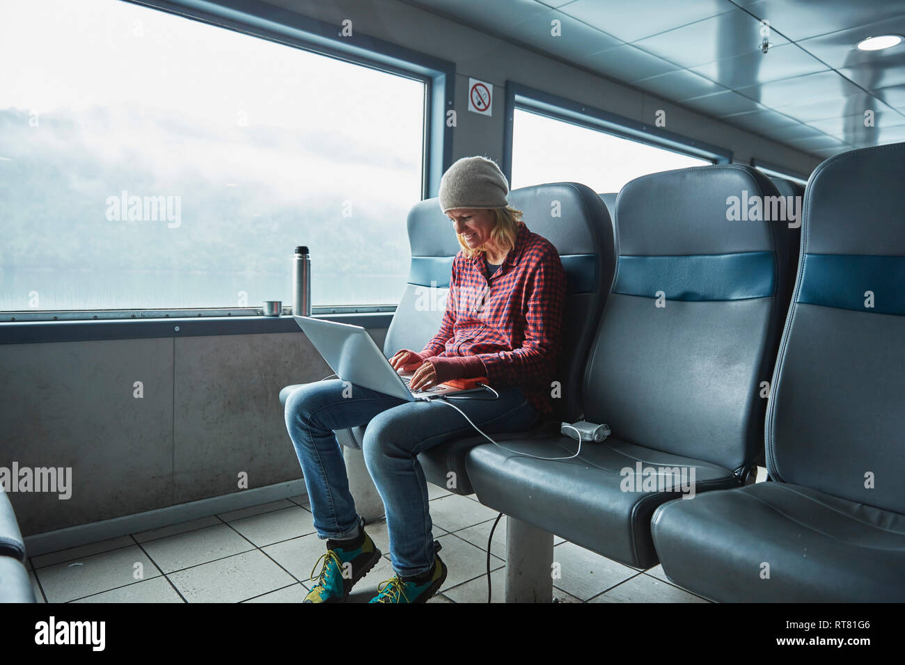 Chile, Hornopiren, Frau mit Laptop in einer Fähre Stockfoto