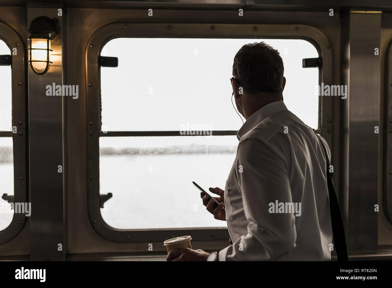 Geschäftsmann auf einer Fähre Blick aus Fenster Stockfoto