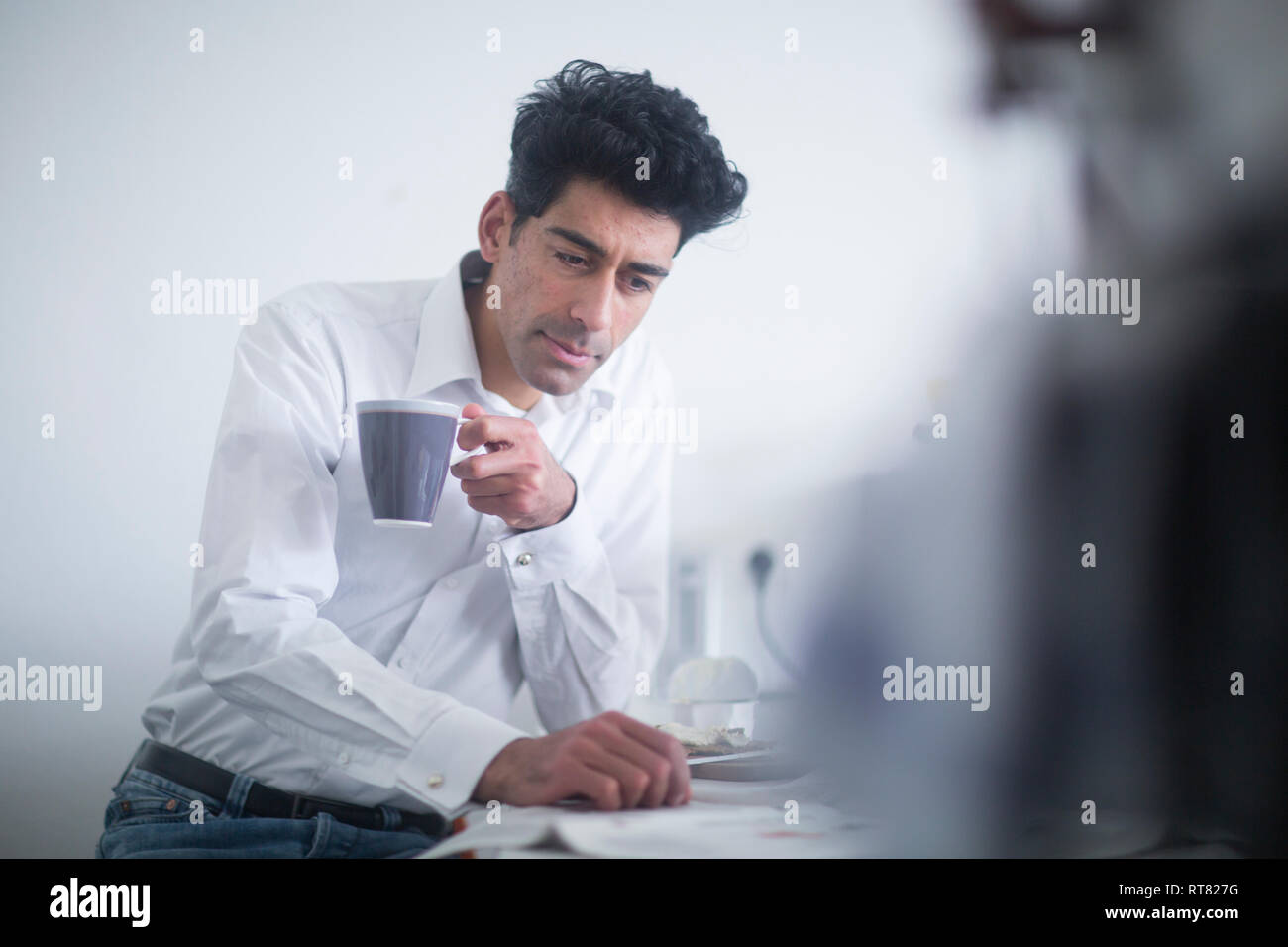 Portrait von Geschäftsmann trinken Kaffee beim Lesen der Zeitung am Morgen zu Hause Stockfoto