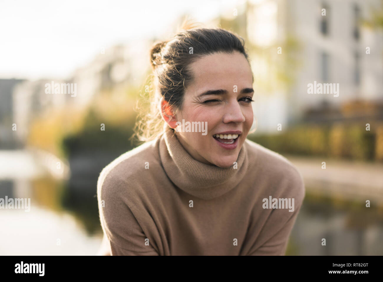 Portrait von winking Frau trägt Hellbraun rollkragen pullover im Herbst Stockfoto