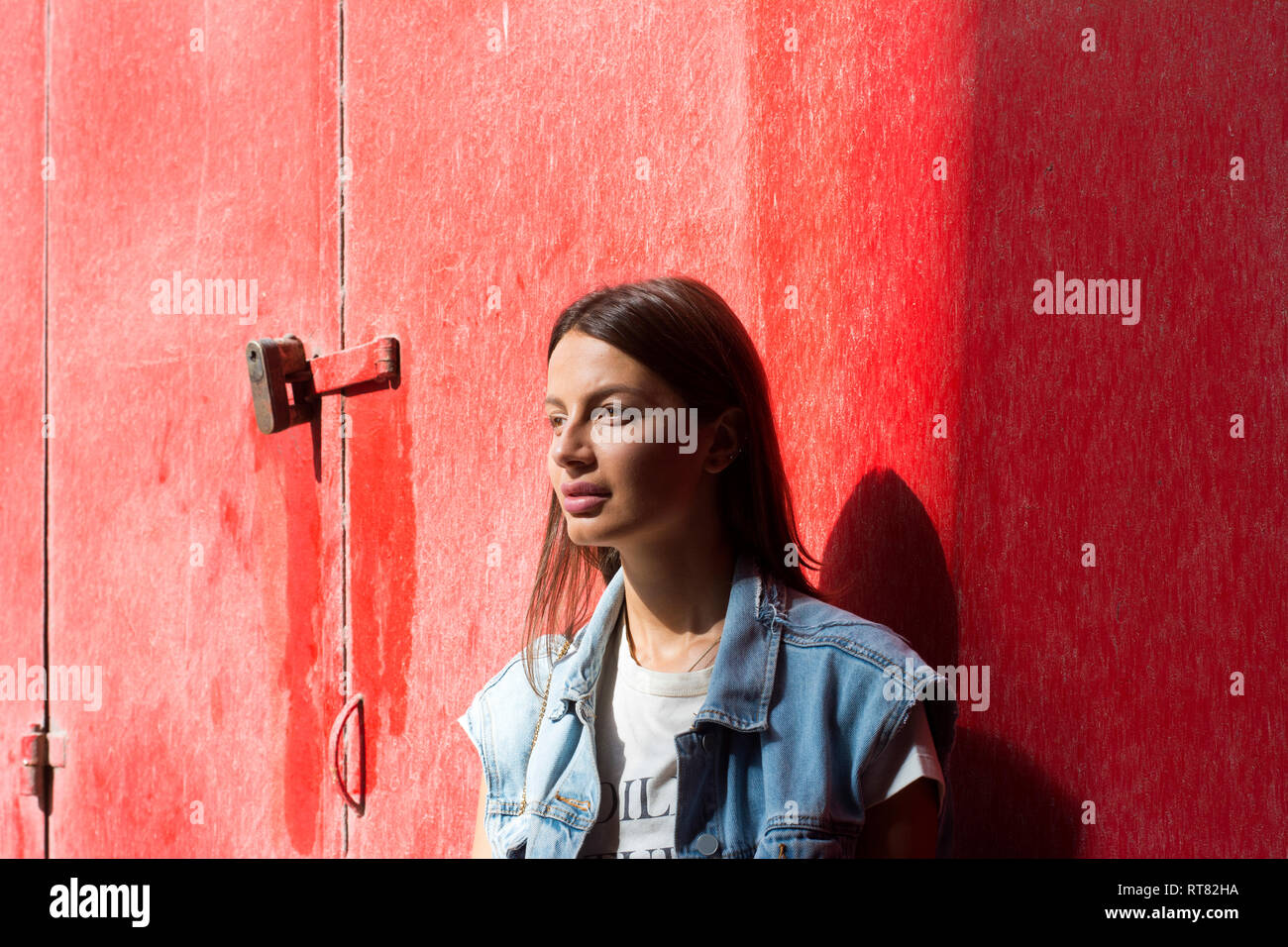 Portrait von Träumen junge Frau vor rotem Hintergrund Stockfoto