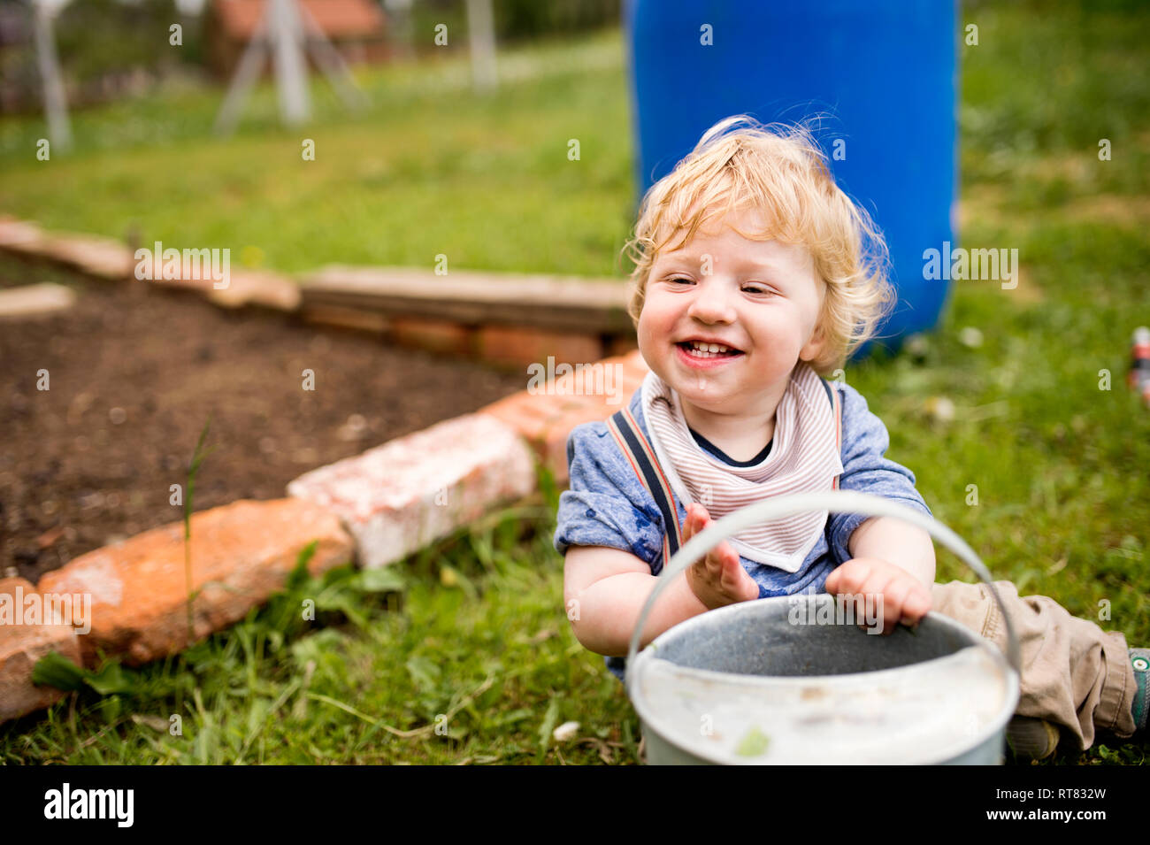 Junge im Garten spielen mit Gießkanne Stockfoto