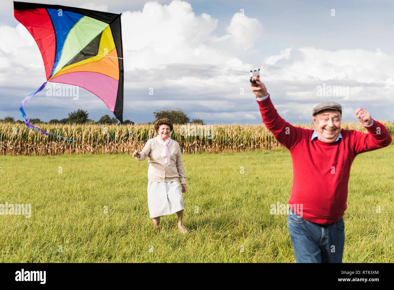 Gerne älteres Paar fliegende Drachen in ländlichen Landschaft Stockfoto