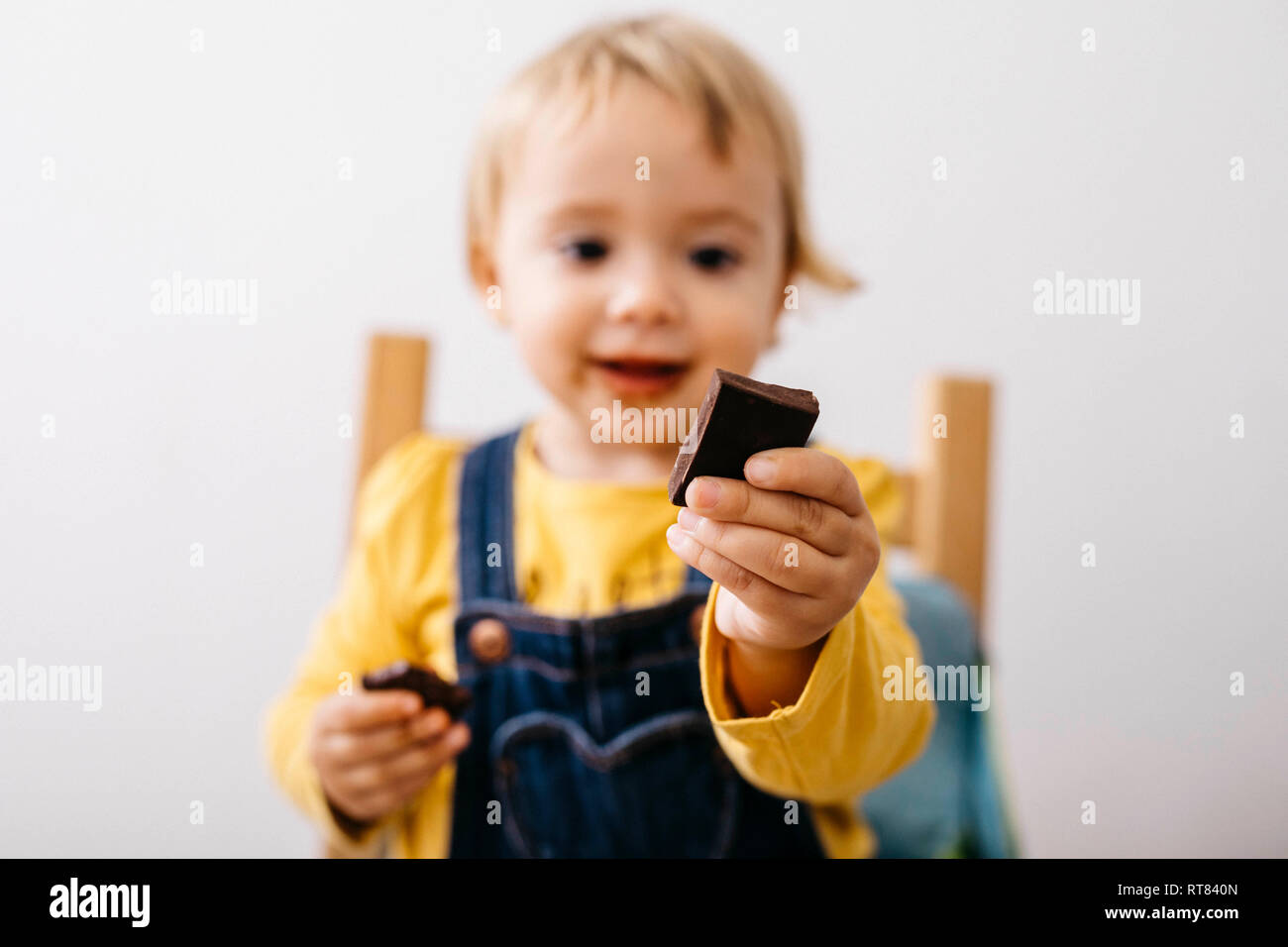 Hand lächelnd Kleinkind Mädchen holding Stück Schokolade, close-up Stockfoto