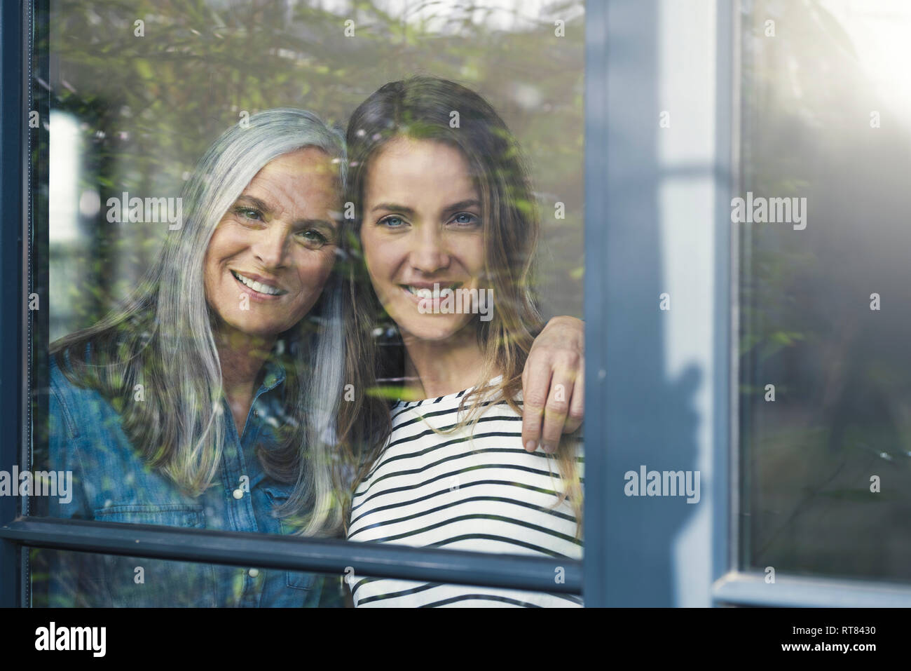 Mutter und Tochter Blick aus Fenster Stockfoto